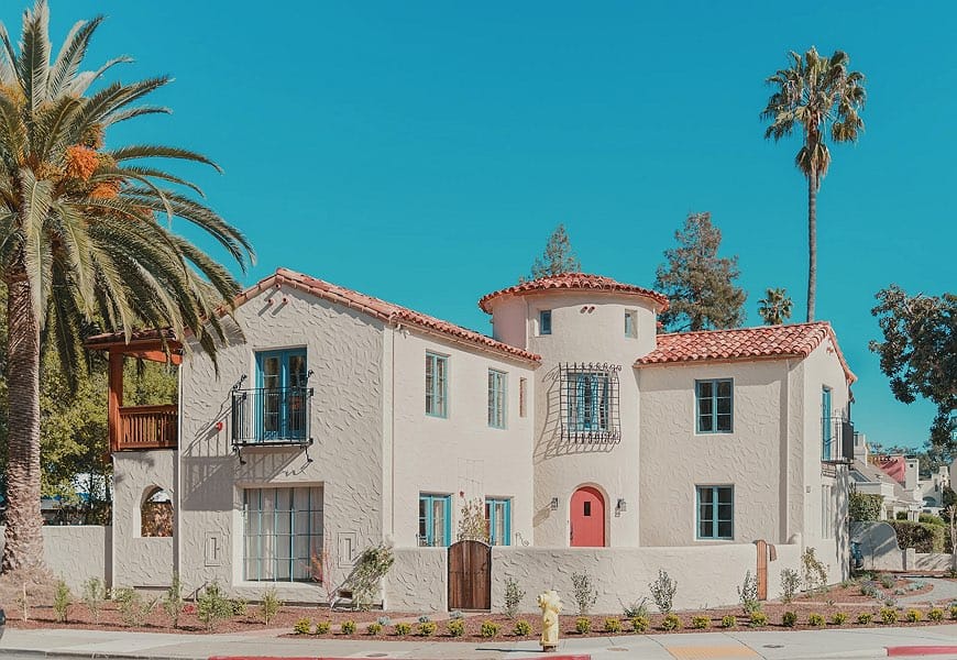 A Spanish-style house with a white exterior and low-pitched roof.