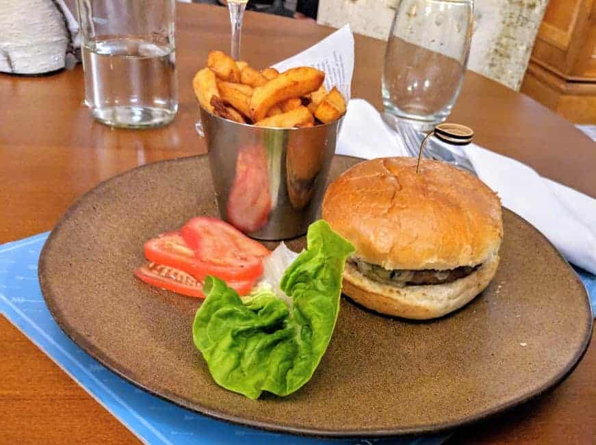 burger, chips, lettuce and tomato on a plate.