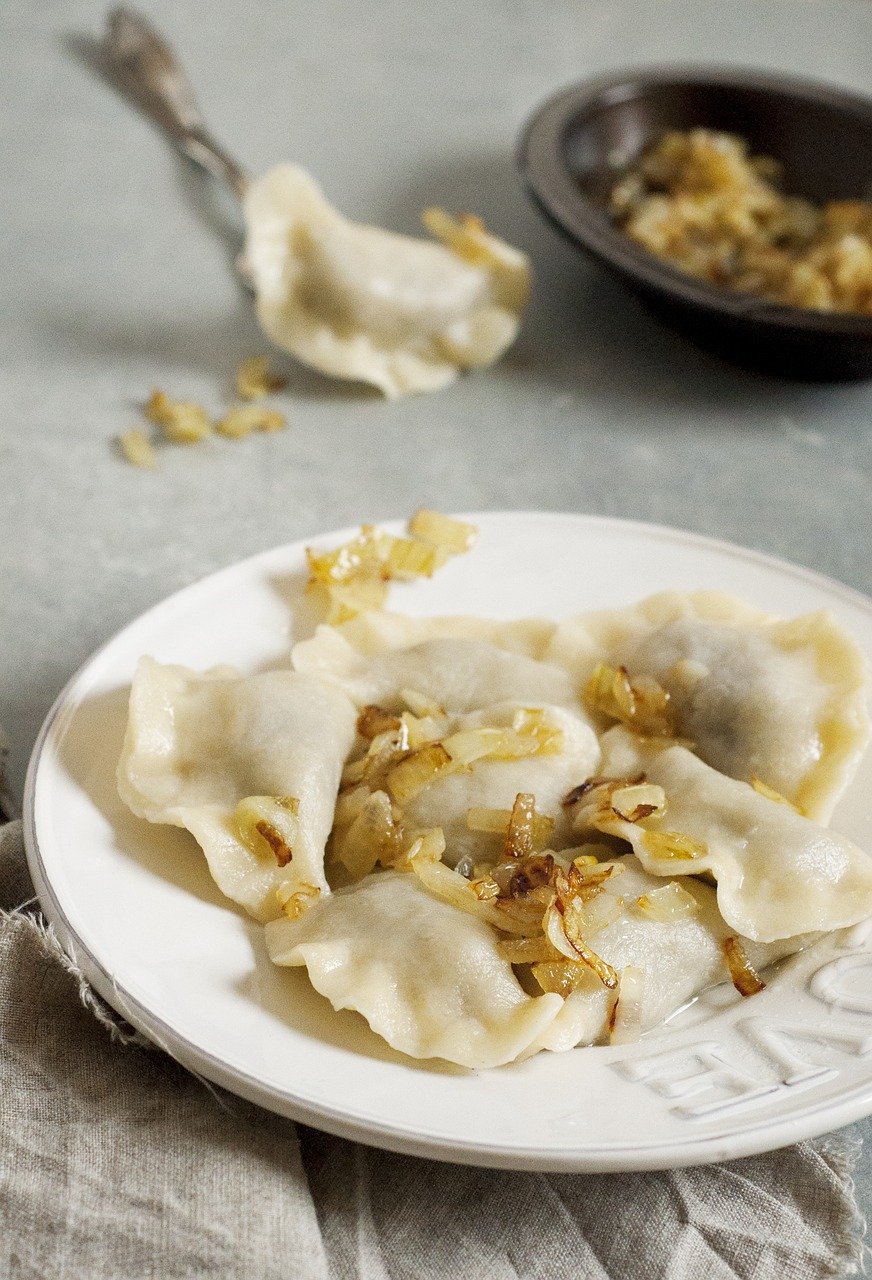 A plate of authentic Polish sauerkraut pierogi with onions.