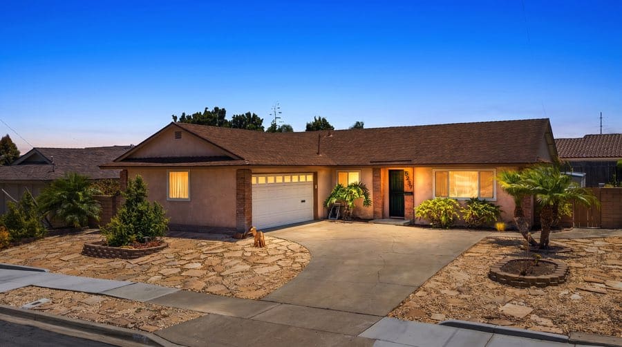 Single-story house with a brown shingle roof, tan stucco walls, and a concrete driveway leading to a white garage door at 5237 Diane Ave in Clairemont.