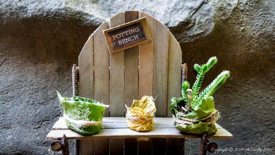 Make this adorable fairy potting bench using rusty nails and stirrer sticks. Quick and easy craft idea for your miniature garden #FairyPottingBench #FairyDIYCrafts #ACraftyMix #FairyGardens #FairyCrafts #WhimsicalFairyCrafts #SimpleFairyCrafts #MiniaturePottingBench #RustyNails