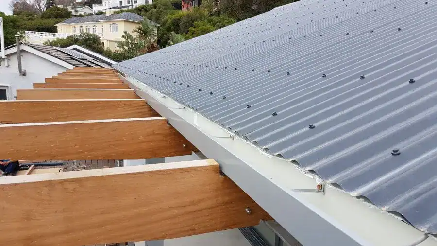 Custom-manufactured industrial-grade aluminium box gutters being installed on a timber roof structure.