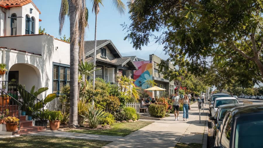Tree-lined street scene in University Heights, San Diego, with Spanish Colonial and Craftsman homes, cafés, and a colorful mural