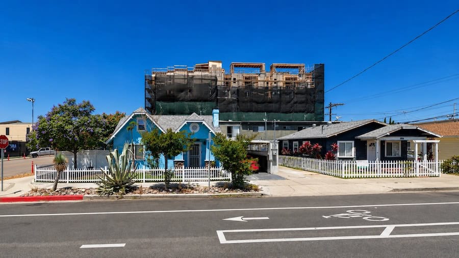 North Park San Diego homes with a multi-story residential building under construction in the background.
