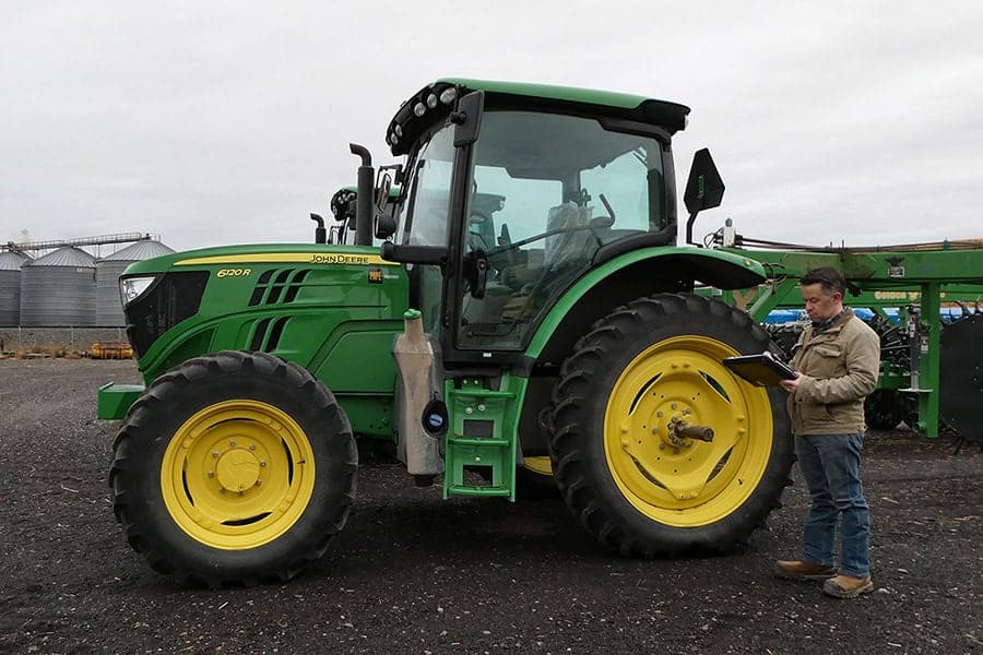 garrett-schwartz-asa-cea-inspecting-farm-tractor Garrett Schwartz ASA CEA inspecting farm tractor for equipment appraisal