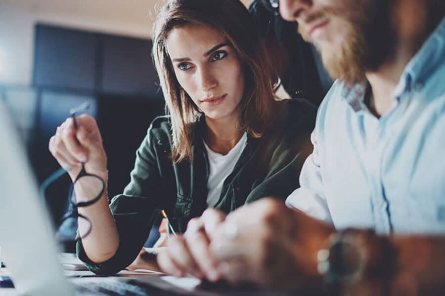 Business Woman And Man Intently Viewing Computer Screen