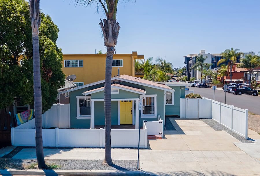 North Park Bungalow alongside modern mixed-use development on a clear sunny day