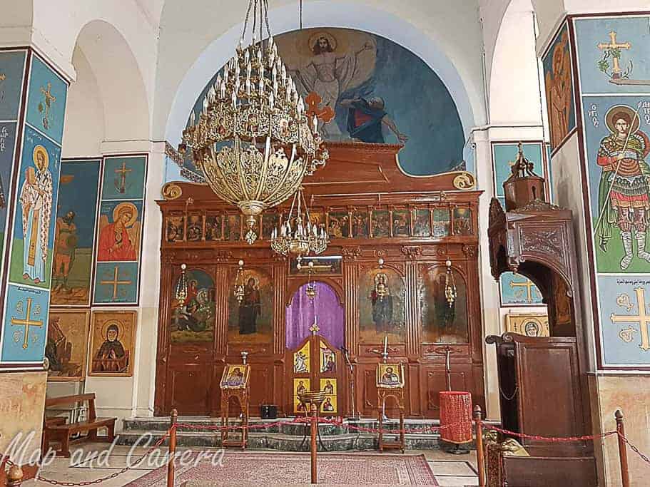 Interior of St. George’s Church in Madaba, Jordan, featuring ornate chandeliers, vibrant religious icons, and intricate woodwork, a must-visit site for history and culture enthusiasts exploring Jordan.