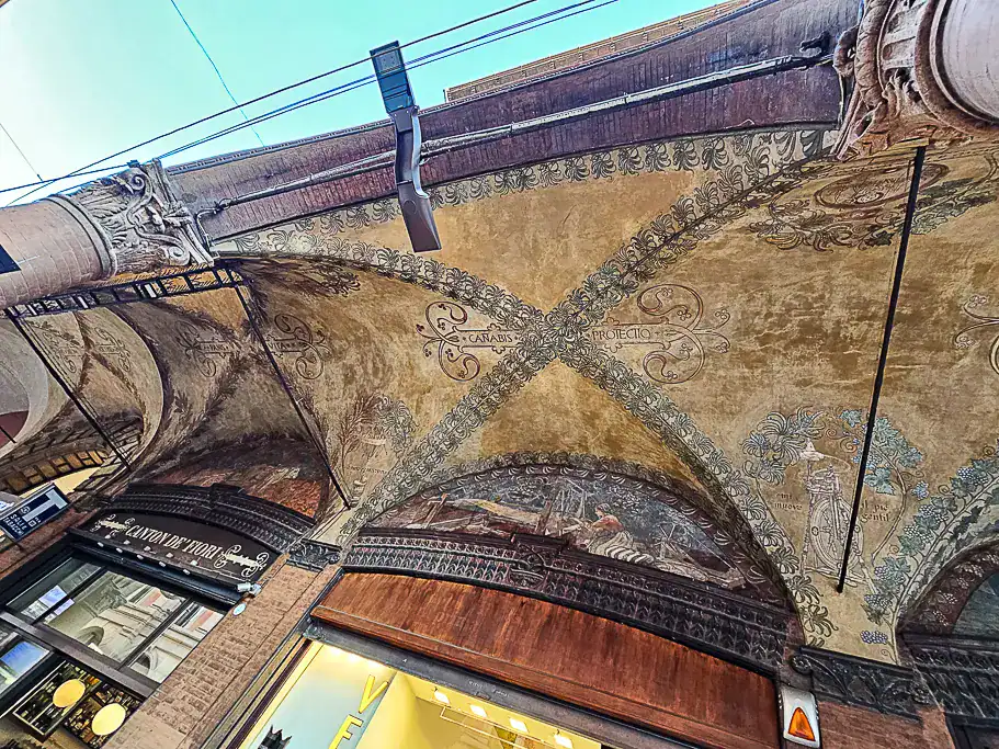 Ceiling fresco featuring the mysterious Latin phrase “Canabis Protectio” in Bologna, a little-known symbol from the city’s portico-covered streets.