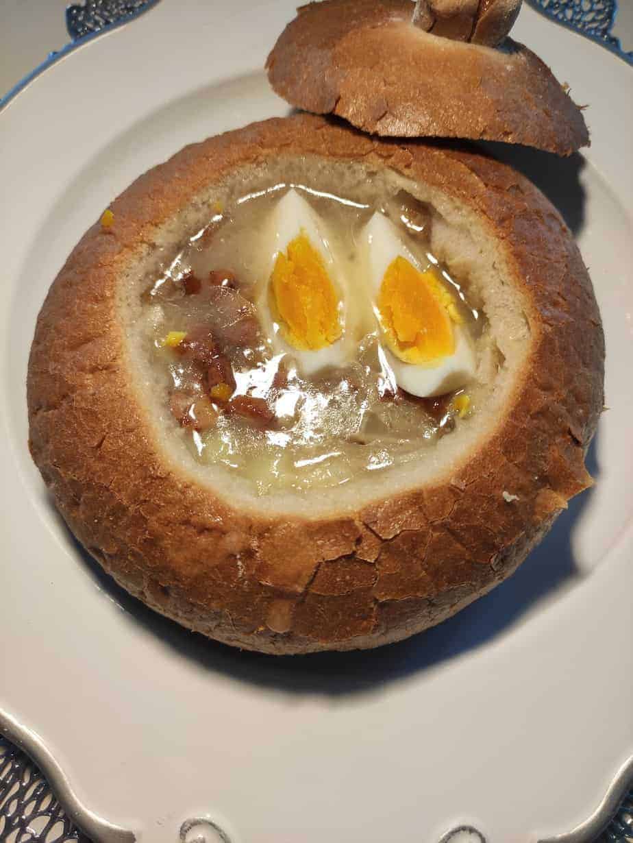 Zurek soup in a homemade bread bowl with egg wedges.