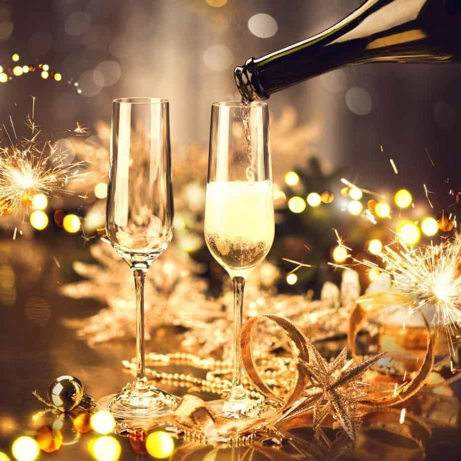 holiday party champagne in glasses with sparkles. Keeping Kitty out of your alcohol is one of the holiday safety tips for cats.