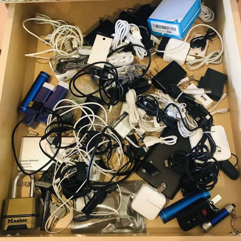 Messy junk drawer filled with tangled cords