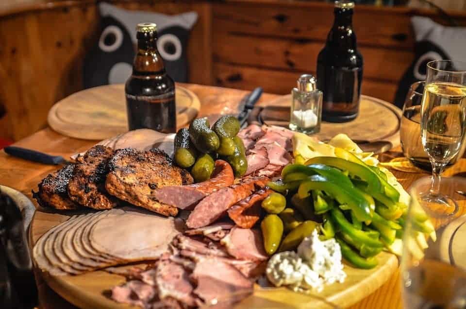 Meats and veggies on a board.