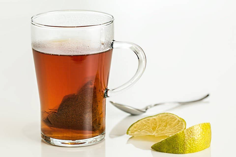 sliced lemons next to a glass of tea.