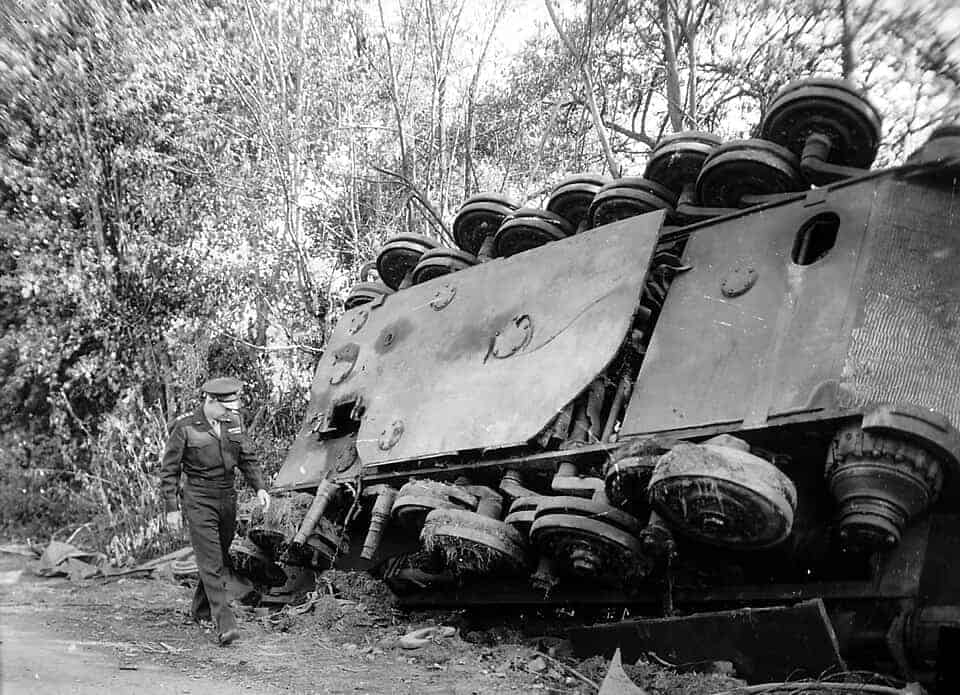 Eisenhower inspecteert een gekantelde Duitse tank langs de weg in Frankrijk, achtergelaten door terugtrekkende troepen.