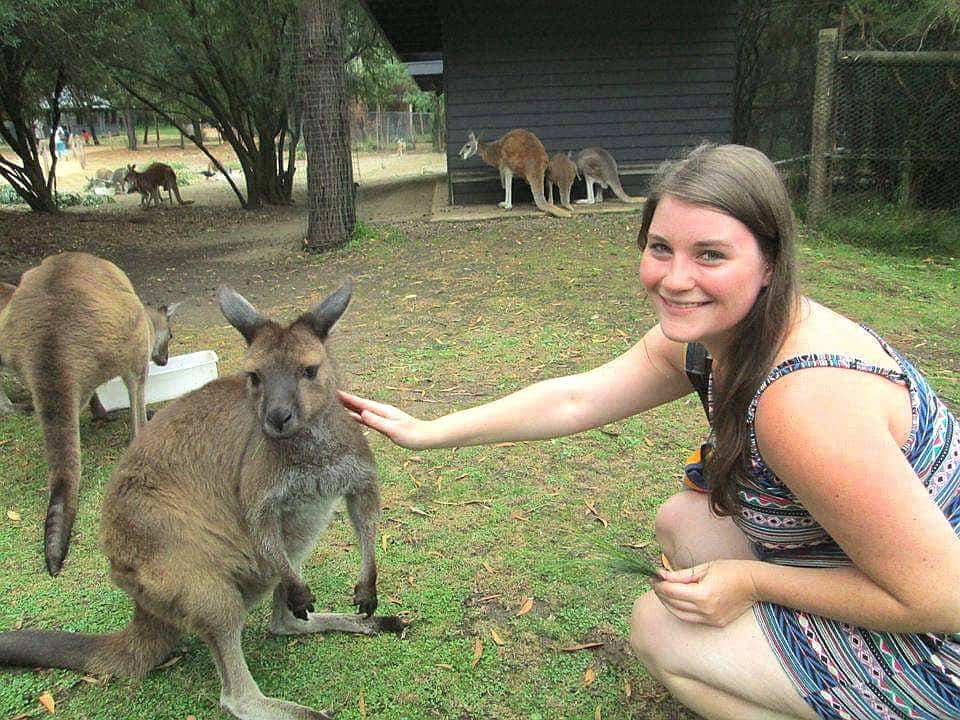Me, knelt down, gently petting a small kangaroo