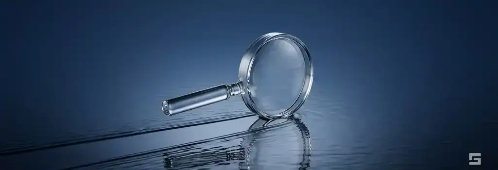 A clear glass magnifying glass clearing a path over dark water, symbolizing the expungement of a criminal record. Legal resources from Grano Law Offices, P.C.