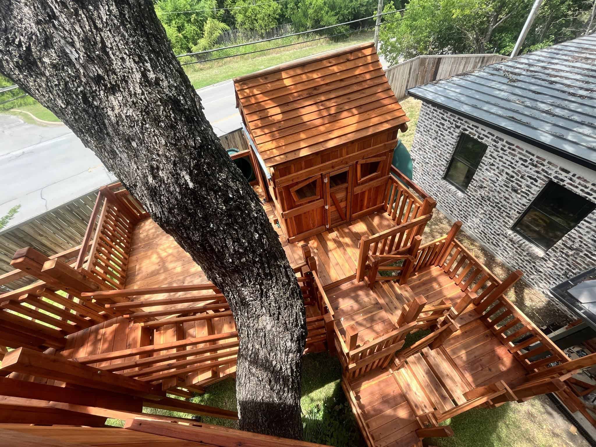 Custom tree house with multiple deck levels, bridges, slides and swings