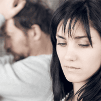 Disinterested couple sitting on couch.