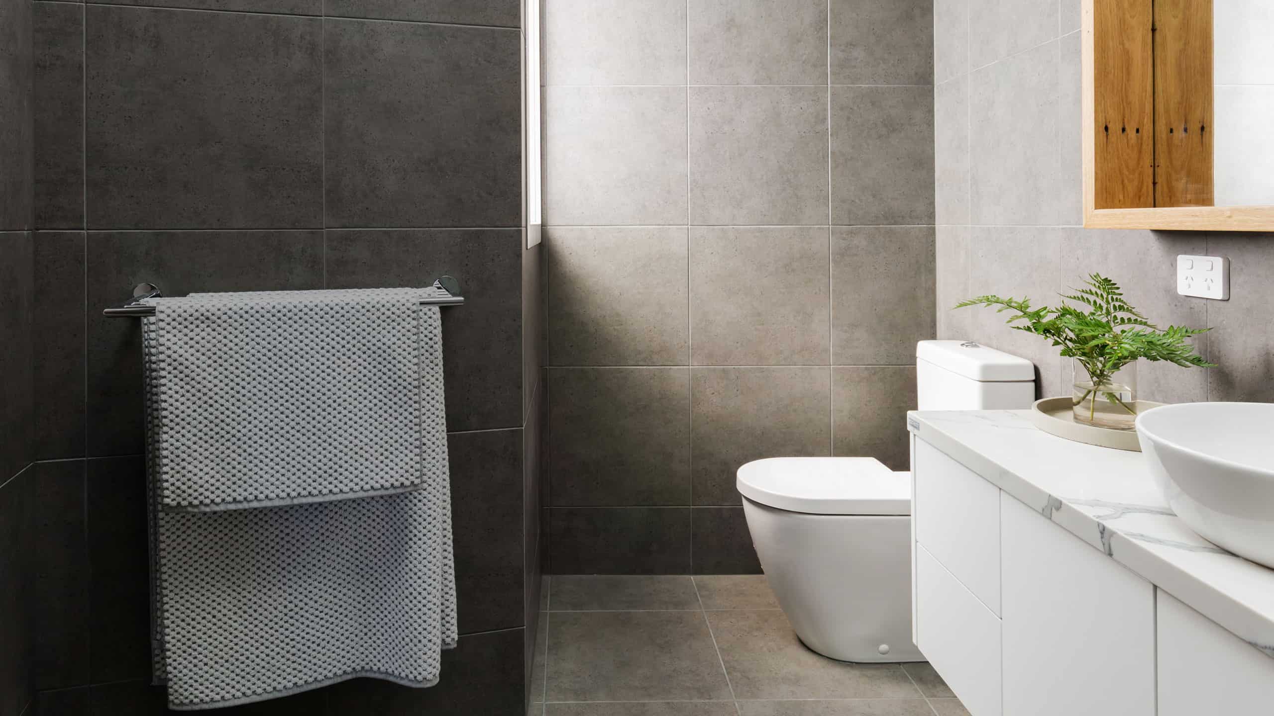 Modern luxury toilet with wall tiles and marble benchtop