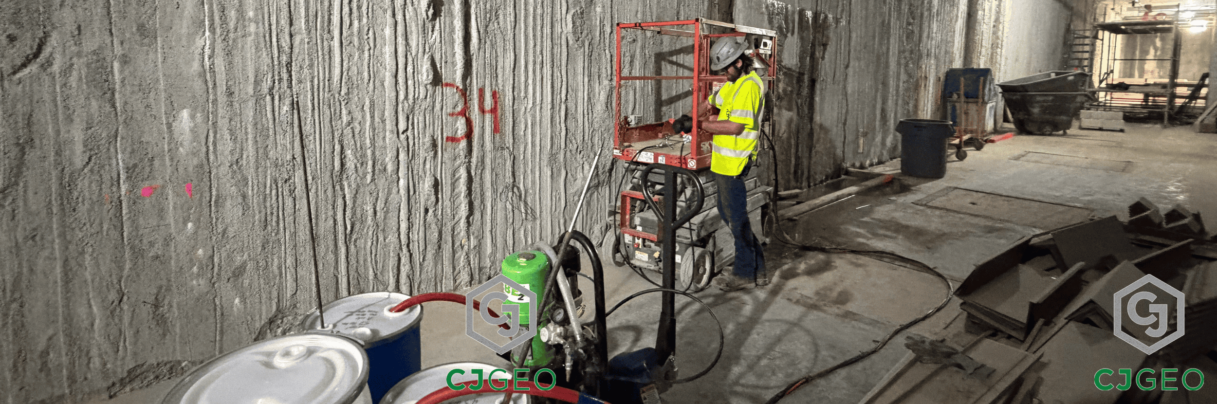 a worker, lift and grouting equipment inside a slurry wall basement