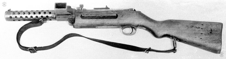 In this left side view of the modified MP 18-I the new magazine housing to accept the 20-round box magazine can be plainly seen. Just above and behind the magazine housing is a special bolt lock system that was placed on MP 18 weapons that were issued to German police in post WWI Germany. The system would lock the bolt solidly in the forward position, preventing any accidental discharge if the weapon was dropped or struck solidly on the butt. PHOTO CREDIT: US Army
