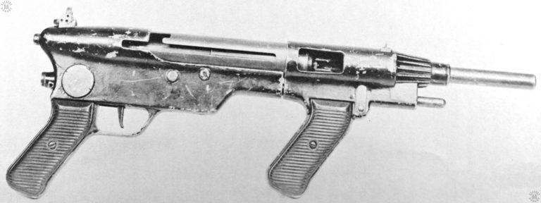 The right side of an Austen Mk II with the stock assembly removed. The magazine is inserted into the mag well, as can be seen by the visible magazine feed lips just inside of the ejector opening. Though the MP-40 style telescoping mainspring assembly is in place, the bolt is missing on this specimen. PHOTO CREDIT: US Army