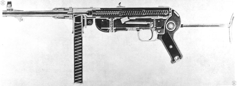 A cross-sectioned view from the left side of an MP40 submachinegun. The magazine is empty but a fired cartridge case is in the chamber. Inside the telescoping mainspring housing can be seen both the much larger mainspring as well as the much smaller buffer spring at the center front of the mechanism. The buffer spring softens the blow of the bolt reaching the end of its recoil, helping to lighten felt recoil by the shooter as well as prevent damage to the weapon. PHOTO CREDIT: US Army