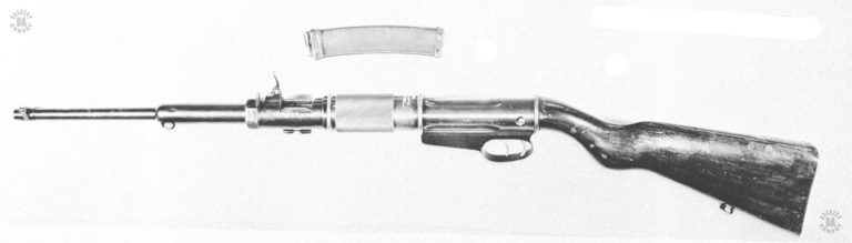 A left view of the OVP conversion of the Villar Perosa. The 245-round magazine has been removed from the weapon and is lying across the top of the picture. The twin triggers are also more visible at this angle. PHOTO CREDIT: US Army