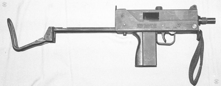 The is the right side of the Ingram M10 9mm submachinegun. The caliber can be identified by the markings on the side of the weapon, above the magazine well. The caliber of the weapon can also be seen by the flat sides of the magazine well which accepts a smaller magazine that the .45 ACP version of the M10.