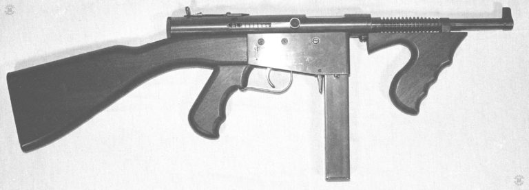 The right side of a production Police Ingram model 6 submachinegun. The large “King” rear sight indicates that this is an early production model. The long safety/selector lever above and behind the trigger is set in the full automatic position. With the selector set on Full automatic, the progressive trigger will give semiautomatic fire when pulled partway to the rear, and full automatic when pulled all the way to the rear of its travel. The Police model is identified by the vertical foregrip and finned barrel. PHOTO CREDIT: Kevin Dockery