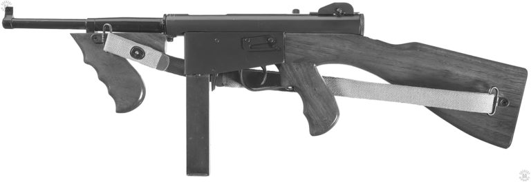 The left side of a late production Ingram Police model 6 submachinegun. It has the later model rear sight with the tall protective “ears” on either side of the raised notch rear sight itself. The barrel has a thick, unfinned area around the breech. The lug sticking up from the receiver in front of the rear sight is the cocking handle, indicating by its position that the weapon has the bolt cocked to the rear. PHOTO CREDIT: ROCK ISLAND AUCTIONS