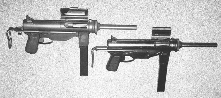 Looking down from the upper side of the weapons, the M3A1 (on the left) and the M3 (on the right) may be compared. Both weapons have their ejection port covers open and the bolts are cocked to the rear in the firing position. Many war production M3 submachineguns were blued and so appear dark in pictures. Later production M3A1s were parkerised with a gray finish. Both if these weapons have their stocks collapsed and are ready for firing. PHOTO CREDIT: Kevin Dockery