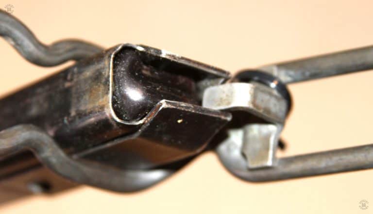 This is the loading tool on the stock of the M3A1 ready for use. The double column, single feed magazine design uses a heavy spring to push the round stack up into position for chambering into the weapon. To overcome this spring pressure when loading the magazine, the lug pushes down on the round as the operator placed it under the feed lips. The magazine bottom is braced against a solid object and held in the correct position by the shape of the butt section of the stock. Without the use of a tool like this, the magazine is extremely hard to fully load by simple finger pressure on the rounds. PHOTO CREDIT: Kevin Dockery