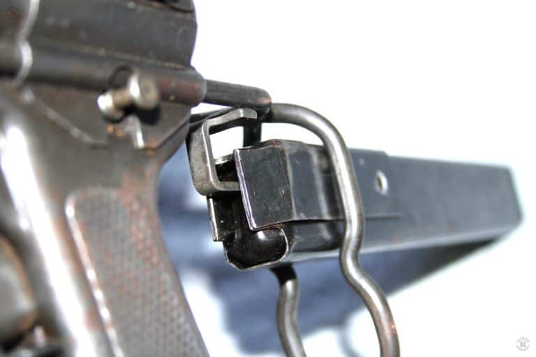 The loading tool on the buttstock in place for loading a magazine. The tool may be used in this manner, with the stock in place on the weapon, but it is more convenient to use after removing the stock from the weapon. At the top of the pistol grip is the stock catch. Pressing in on this button unlocks the stock to be extended. If the stock catch is held in, the stock can be slid out of the receiver. PHOTO CREDIT: Kevin Dockery