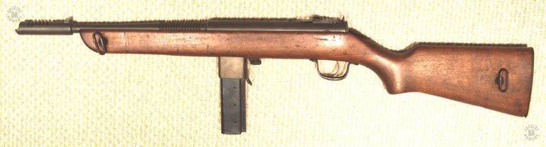 The left side of a Reising M50 showing the side-mounted locations of the sling swivels. Mounting the swivels on the side allows the weapon to be comfortable slung over the shoulder when there is a magazine loaded in place. The magazine loaded in this specimen is an early model 20 round specimen, notable because of the ammunition indicator holes on the left side of the body. PHOTO CREDIT: Kevin Dockery