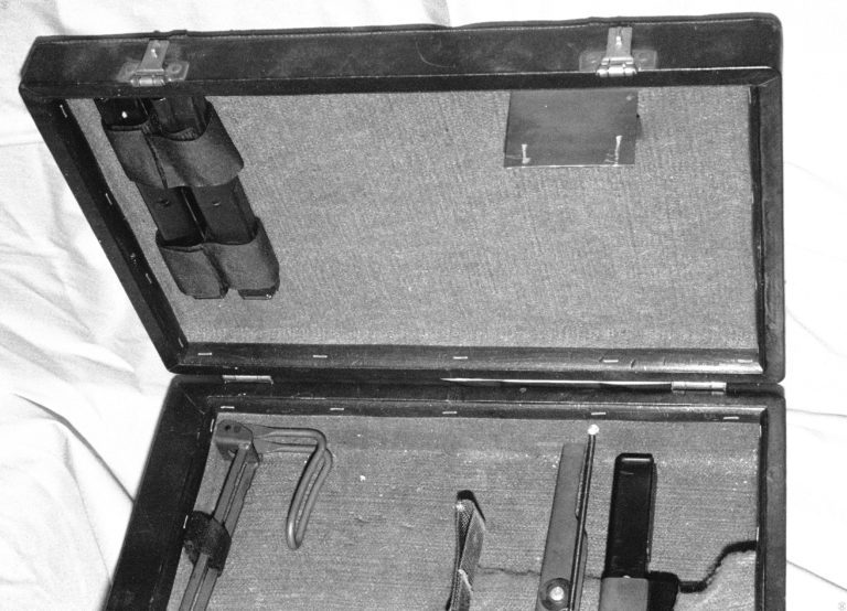 The top cover of the Operational Briefcase for the Ingram M11 submachinegun. Two spare magazines are on the left side of the cover, held in place with Velcro straps. On the right side of the case lid is a sheet steel deflector shield. The shield helps direct ejected casings from the firing submachinegun down into the base of the case, away from the operating weapon. This helps keep the ejected casings from interfering with the weapon, possibly jamming it. PHOTO CREDIT: Kevin Dockery