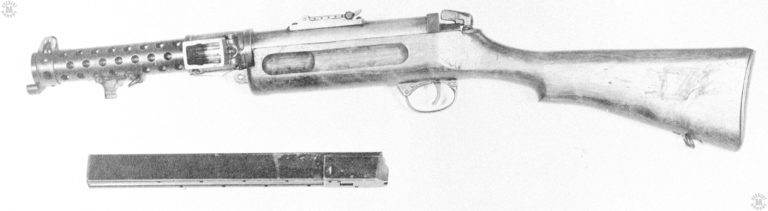 This is a left side view of a Lanchester Mk I converted to the Mk I* version. The primary difference between the Mk I and the Mk I* is that the latter is made for full-automatic fire only. The two pins on the front of the trigger guard show where the selector mechanism was removed and a cover secured over the opening. This specimen has the early-model tangent rear sight on top of the receiver. The rear catch that unlocks the upper and lower receivers is plainly seen as the serrated lever at the rear of the receiver. The magazine laying across the bottom of the picture is the standard 50-round model produced at the request of the Royal Navy. PHOTO CREDIT: US ARMY