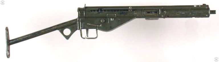 A right-side view of a Sten Mk III coated with worn green paint. The bolt is in the forward position and the weapon is fitted with the common No 2 Mk II “T” stock. PHOTO CREDIT: SPRINGFIELD ARMORY NATIONAL HISTORIC SITE