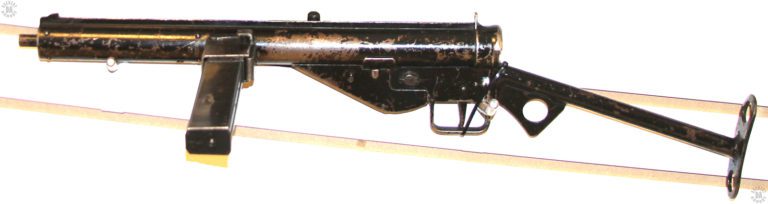 This is a left-side view of a Sten Mark III with a worn coat of black paint. A large number of war production Stens were simply coated with paint as a final finish, usually over a grey coating of phosphate. The Mk III Sten was the simplest, cheapest, and fastest to produce of all of the Sten family, exactly what was needed by England during the early part of World War II. PHOTO CREDIT: KEVIN DOCKERY
