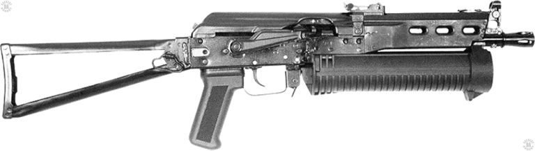A right-side view of the Bizon-2 submachinegun with the stock extended and locked into place. The Safety/selector lever at the center of the receiver, above the trigger, is up in the Safe position. With the selector in the up position, the bolt is locked in the forward position. The front “hook” for the magazine can be seen at the bottom of the muzzle, behind the front sight assembly. PHOTO CREDIT: RUSSIAN FEDERATION