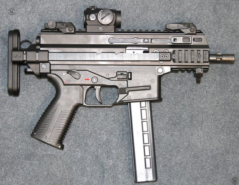 The right side of an ATC9K with the stock in the collapsed position. In this view it can be seen that all of the controls of the weapon are duplicated from the left side. The ejection port, partially concealed behind the right stock strut, is large enough for fired brass to be cleanly ejected even with the stock folded. In front of the trigger is the magazine release which is longer on the right side of the weapon to engage the magazine. PHOTO CREDIT: KEVIN DOCKERY