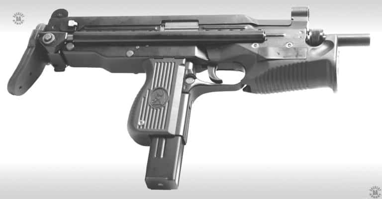 The right side of the PM-68 submachinegun. The large rectangular surface on the wide front grip would be where a switch could be mounted when a laser or illuminator is installed on the weapon.  This specimen is loaded with a 25-round magazine that extends slightly below the pistol grip. Behind and below the trigger is the right side of the magazine catch. There is a corresponding semicircular guard above the catch for when the weapon is fitted with the optional right-side magazine catch. The small switch on the receiver just behind the pistol grip is a further, ambidextrous, selector switch without the markings on the receiver to indicate the position of the switch. The stock is fully telescoped and locked in place.  PHOTO CREDIT: FABRYKA BRONI