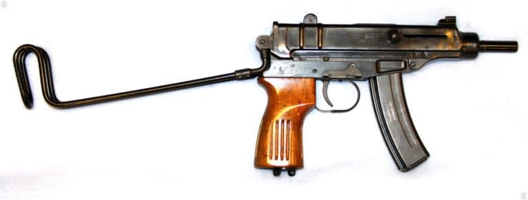 The right-side of a Skorpion Vz-61. The stock has been unfolded and locked into the open position. The weapon is loaded with an empty 20-round magazine. The bolt is locked to the rear indicating that the weapon has an empty magazine. The ejection port is on the top of the receiver and the weapon is known for ejecting fired brass straight up into the air when it is fired. At the base of the exposed barrel can be seen the small ring that helps secure the collet of the suppressor when it is mounted. PHOTO CREDIT: KEVIN DOCKERY