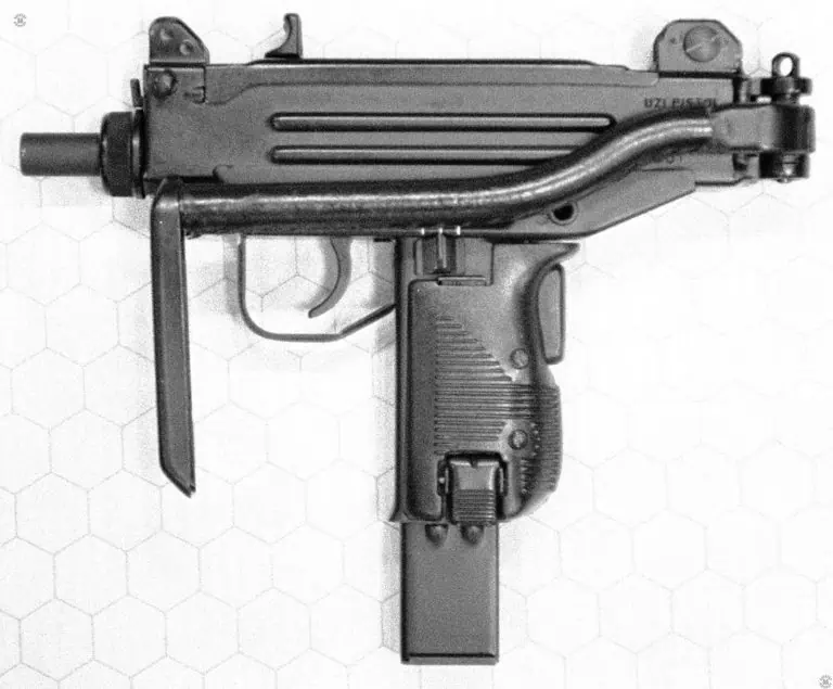 A left-side view of a Micro-Uzi conversion of an Uzi pistol. This is one of the early conversions done my IMI as they were developing the weapon. The stock is folded to the left side of the weapon with the butt in a position to be used as a vertical front grip. The hand holding the but can also hook a thumb through the front of the trigger guard. The safety/selector switch at the top of the pistol grip is set to the center semiautomatic fire position. The magazine is the 25-round model. The stock is covered by a stitched-on leather sheath. PHOTO CREDIT: KEVIN DOCKERY