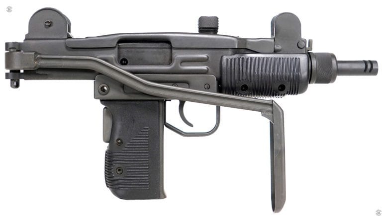 The right side of an unloaded Mini-Uzi with the stock folded. The stock is held in place by the mechanism at the rear of the receiver. The spring-loaded stock lock has a small upper lug in the mechanism that pops up into the corresponding notch on the inside top of the lock. A hard strike against the left side of the buttplate extending below the foregrip of the weapon unlocks the stock and it folds out and snaps into the extended position. The bolt is in the forward, uncocked, position on the specimen. PHOTO CREDIT: IMI