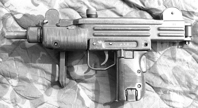 The left side of an unloaded Mini-Uzi. This is a sterilized version sold on the international market with only a serial number, in this case “88,” Marked on the side of the weapon. The markings for the selector switch, at the top of the pistol grip, are A, R, and S, for Automatic, Repeat (Semiautomatic), and Safe. The sliding selector switch, directly behind the trigger, is set to the forward, “A” position for full automatic fire. At the rear of the pistol grip is the grip safety that is held in by the web of the thumb of the firing hand. The buttplate of the folded stock, on the right side of the weapon, extends down from the forearm, where it can be held by the non-firing hand. PHOTO CREDIT: KEVIN DOCKERY