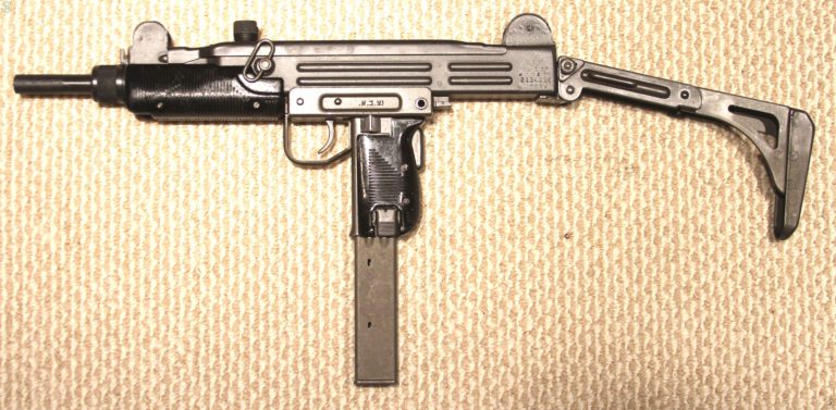 The left side of an Uzi, Number 2, Version 1 with the folding stock locked in the extended position. The specimen is loaded with a 40-round magazine. The selector switch is set to the central position for semiautomatic fire. PHOTO CREDIT: KEVIN DOCKERY