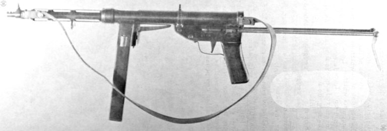 A left side view of the TZ-45. The magazine well grip safety stands out plainly with its long leg entering the center of the receiver. There is a two-slot compensator on the muzzle of the weapon. The skeletal barrel jacket is just sufficient to cover a hot barrel and protect the operator from it. PHOTO CREDIT: US Army
