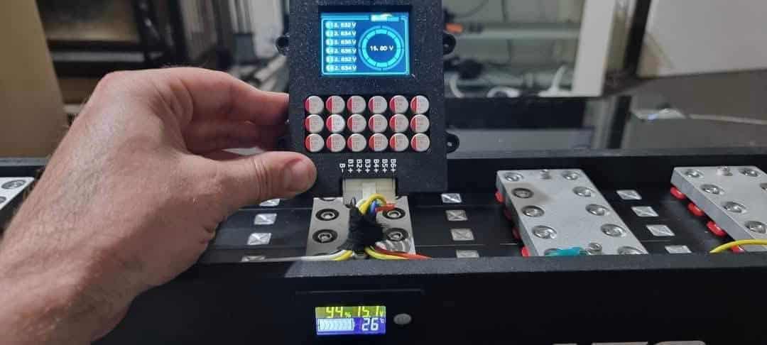 Hand adjusting battery voltage display.
